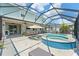 Covered and screened-in pool area with a built-in spa, outdoor lounge furniture, and lush landscaping at 11742 Lake Lucaya Dr, Riverview, FL 33579
