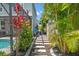 Landscaped side yard walkway featuring pavers, tropical plants, and access to the screened pool area at 11742 Lake Lucaya Dr, Riverview, FL 33579