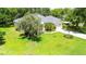 Aerial view of a single-Gathering home with lush landscaping and a spacious front yard at 12435 Oak St, San Antonio, FL 33576