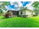 Backyard with a screened-in lanai, landscaping, and a well-maintained lawn at 12435 Oak St, San Antonio, FL 33576