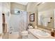 Cozy bathroom featuring shower over tub, neutrally patterned shower curtain, framed mirror, and vanity at 12435 Oak St, San Antonio, FL 33576