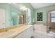Light-filled bathroom with double vanity, soaking tub, and tiled shower, creating a luxurious spa-like experience at 12435 Oak St, San Antonio, FL 33576