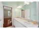 Bathroom with double sinks, white cabinetry, and neutral paint at 12435 Oak St, San Antonio, FL 33576