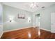 Bright bedroom features hardwood floors, sconce lighting, ceiling fan, and ensuite bathroom access at 12435 Oak St, San Antonio, FL 33576