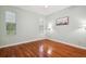 Spacious bedroom with hardwood flooring, neutral paint, and natural light from two windows at 12435 Oak St, San Antonio, FL 33576