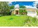Beautiful home with lush green lawn and landscaping, a three-car garage, and attractive curb appeal at 12435 Oak St, San Antonio, FL 33576