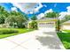 Spacious home with a large driveway, three-car garage, and a well-manicured lawn and blue sky at 12435 Oak St, San Antonio, FL 33576