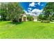 Inviting single-story home with manicured lawn, beautiful landscaping, and a side-entry garage at 12435 Oak St, San Antonio, FL 33576