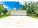 Detached three-car garage with a long driveway, well-kept lawn and good lighting at 12435 Oak St, San Antonio, FL 33576