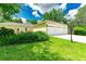 Detached three-car garage with a long driveway, well-kept lawn and privacy trees at 12435 Oak St, San Antonio, FL 33576