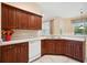 Well-lit kitchen features dark wood cabinets, a double sink, tile backsplash, and white appliances at 12435 Oak St, San Antonio, FL 33576