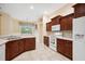Spacious kitchen with dark wood cabinets, tile floor, white appliances, and breakfast nook at 12435 Oak St, San Antonio, FL 33576