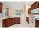 Kitchen with dark wood cabinets, stainless sink, and white appliances at 12435 Oak St, San Antonio, FL 33576