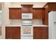 Bright kitchen featuring dark wood cabinets, white appliances and corian countertops at 12435 Oak St, San Antonio, FL 33576