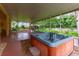 Relaxing screened patio with a luxurious hot tub, perfect for unwinding and enjoying the peaceful outdoor scenery at 12435 Oak St, San Antonio, FL 33576
