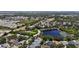 Gorgeous aerial view showcasing a neighborhood with mature trees, a pond, and well-maintained homes at 12443 Adventure Dr, Riverview, FL 33579