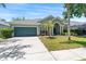 Charming home featuring a well-manicured lawn, mature landscaping, and a two-car garage at 12443 Adventure Dr, Riverview, FL 33579