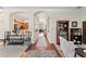 Inviting hallway with arched doorways, hardwood floors, and views into the kitchen and living spaces at 12443 Adventure Dr, Riverview, FL 33579