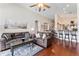 Spacious living room with hardwood floors, leather sofas, and arched doorways to other rooms at 12443 Adventure Dr, Riverview, FL 33579