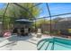 Screened-in pool area with outdoor seating and lush landscaping for ultimate relaxation at 12443 Adventure Dr, Riverview, FL 33579