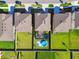 An aerial view of three homes, each with a well-maintained lawn; one has a pool and trampoline at 12643 Horseshoe Bend Dr, Lithia, FL 33547