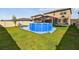 Spacious backyard with a blue pool, green grass, and a screen-enclosed patio area for entertaining at 12643 Horseshoe Bend Dr, Lithia, FL 33547