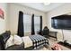 Bedroom featuring a checkered bedspread, gaming setup, and natural light, great for relaxation or study at 12643 Horseshoe Bend Dr, Lithia, FL 33547