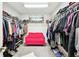 Spacious walk-in closet with ample storage, gray carpet and a comfy pink sofa at 12643 Horseshoe Bend Dr, Lithia, FL 33547