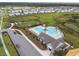 Aerial view of a community pool, clubhouse, playground, and a vast lawn surrounded by houses at 12643 Horseshoe Bend Dr, Lithia, FL 33547
