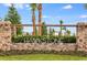 Stone monument sign that reads 'HAWKSTONE' beneath wood beams, with lush greenery surrounding it at 12643 Horseshoe Bend Dr, Lithia, FL 33547