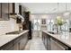 Galley kitchen features stainless appliances, quartz countertops, tile backsplash, and dark cabinets at 12643 Horseshoe Bend Dr, Lithia, FL 33547
