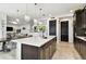 Open concept kitchen with island, quartz countertops, dark cabinets, and flows into the living and dining areas at 12643 Horseshoe Bend Dr, Lithia, FL 33547