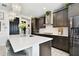 Stylish kitchen featuring dark wood cabinets, a large island with bar stool seating, and stainless steel appliances at 12643 Horseshoe Bend Dr, Lithia, FL 33547