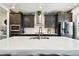 Modern kitchen with stainless appliances, dark cabinets, quartz countertops, and white tile backsplash at 12643 Horseshoe Bend Dr, Lithia, FL 33547