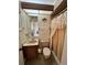 Cozy bathroom featuring a vanity sink and a shower with a decorative lace curtain at 1332 Fuchsia Dr, Holiday, FL 34691