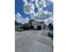 Spacious driveway leading to a single-story home with an attached garage and fenced yard with lawn at 1332 Fuchsia Dr, Holiday, FL 34691