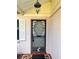 Inviting front door with decorative security gate, brick steps and a pendant light with shuttered window at 1332 Fuchsia Dr, Holiday, FL 34691