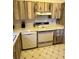Traditional kitchen featuring wood grain cabinets, white appliances, and tile flooring at 1332 Fuchsia Dr, Holiday, FL 34691