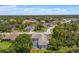 Wide aerial view of a home in a suburban neighborhood surrounded by mature trees and blue skies at 13375 Newcastle Ave, Spring Hill, FL 34609