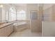 Bright bathroom featuring double sinks, a soaking tub under arched windows, and a walk-in shower at 13375 Newcastle Ave, Spring Hill, FL 34609