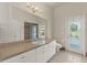Bathroom with a large mirror, vanity and access door to the backyard at 13375 Newcastle Ave, Spring Hill, FL 34609