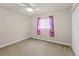Bright bedroom features a ceiling fan and window with colorful curtains at 13375 Newcastle Ave, Spring Hill, FL 34609