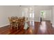Dining room with hardwood floors, a wood table set, and front door view at 13375 Newcastle Ave, Spring Hill, FL 34609