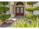 Inviting front entryway featuring double doors with decorative glass and neatly trimmed shrubs on either side at 13375 Newcastle Ave, Spring Hill, FL 34609