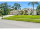 Charming single-story home with a three-car garage, manicured lawn, and mature landscaping at 13375 Newcastle Ave, Spring Hill, FL 34609