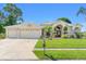 Inviting home with a well-maintained lawn, a three-car garage, and an arched entryway at 13375 Newcastle Ave, Spring Hill, FL 34609
