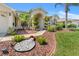 Beautifully landscaped front yard with mature palm trees, manicured shrubs, and decorative rock features at 13375 Newcastle Ave, Spring Hill, FL 34609