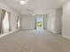 Open living room with neutral carpet, ceiling fans and sliding door to a pool at 13375 Newcastle Ave, Spring Hill, FL 34609