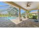 Screened-in patio with tiled floor and ceiling fan overlooking the backyard pool at 13375 Newcastle Ave, Spring Hill, FL 34609
