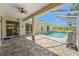 The backyard has a screened pool area with brick flooring and a ceiling fan at 13375 Newcastle Ave, Spring Hill, FL 34609
